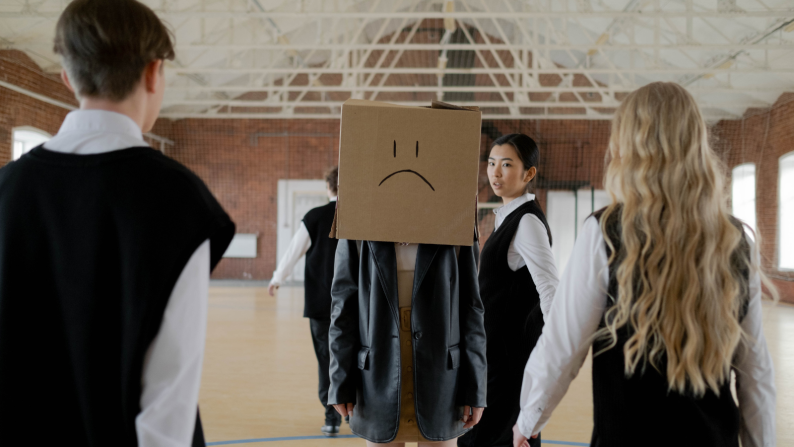 A sad young person with a box on their head